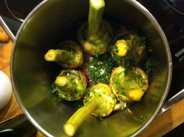 Die Artischocken 5 Minuten bei mittlerer Hitze anbraten. Dann mit trockenem Weißwein ablöschen und ca. 40 Minuten dünsten. Foto © Welz