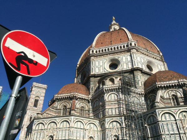 Florenz: Der Campanile, der Dom Santa Maria del Fiore mit der berühmten Kuppel und ein Straßenschild beklebt von Clet Abraham. Mai 2015. Foto © Welz