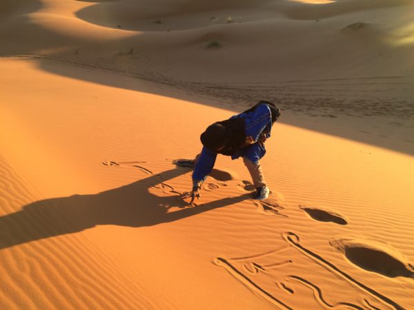 Erg Chebbi: Ein Wüstenbewohner, mein Begleiter, schreibt meinen Namen in den Sand. Foto © Welz